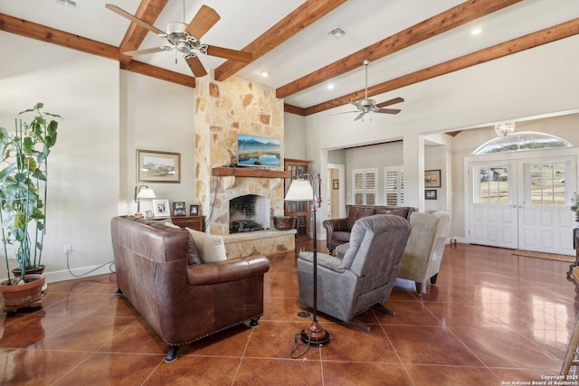 tiled living room featuring beam ceiling, a towering ceiling, a fireplace, and ceiling fan