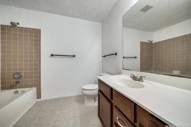 full bathroom featuring tile patterned flooring, tiled shower / bath combo, vanity, a textured ceiling, and toilet