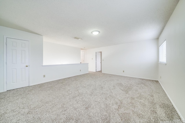 carpeted empty room featuring a textured ceiling