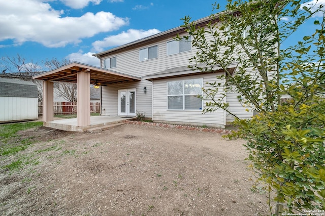 rear view of property featuring a patio area, a shed, and french doors