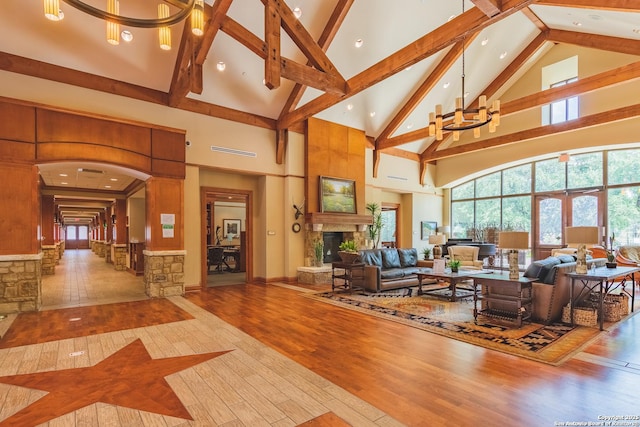 living room with hardwood / wood-style floors, beam ceiling, high vaulted ceiling, and a chandelier