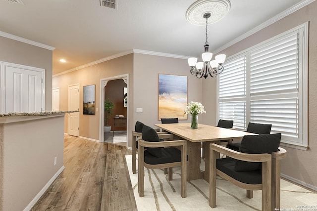 dining room featuring crown molding, a notable chandelier, and light hardwood / wood-style flooring