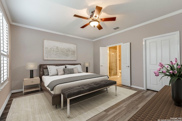 bedroom featuring connected bathroom, hardwood / wood-style flooring, ornamental molding, and ceiling fan