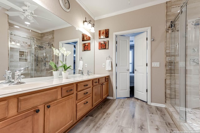 bathroom with hardwood / wood-style floors, vanity, an enclosed shower, ceiling fan, and crown molding