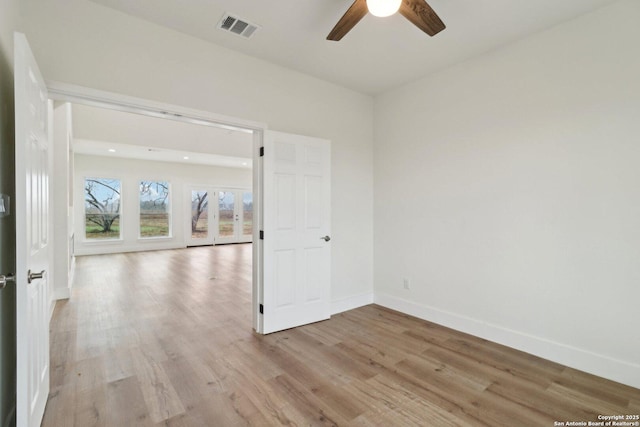 empty room with ceiling fan and light wood-type flooring