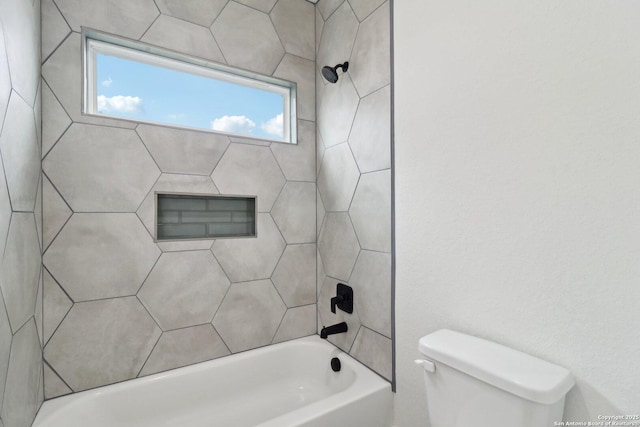 bathroom featuring tiled shower / bath and toilet