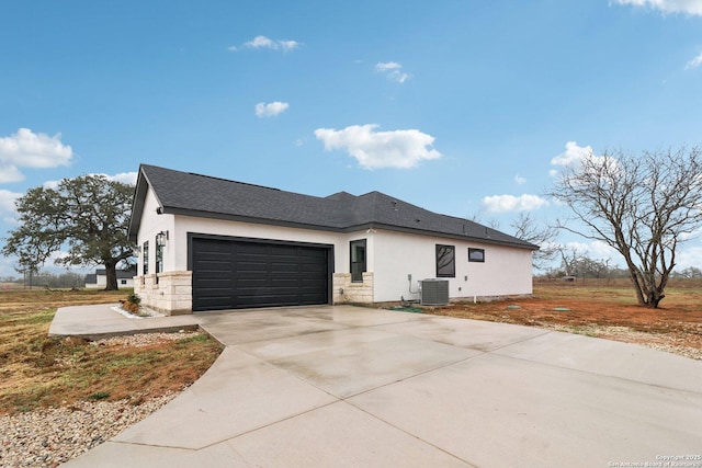 view of property exterior with a garage and central AC