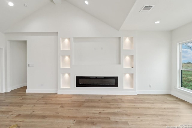 unfurnished living room with heating unit, vaulted ceiling, and light hardwood / wood-style floors