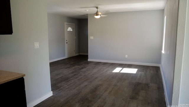 empty room with dark wood-type flooring and ceiling fan