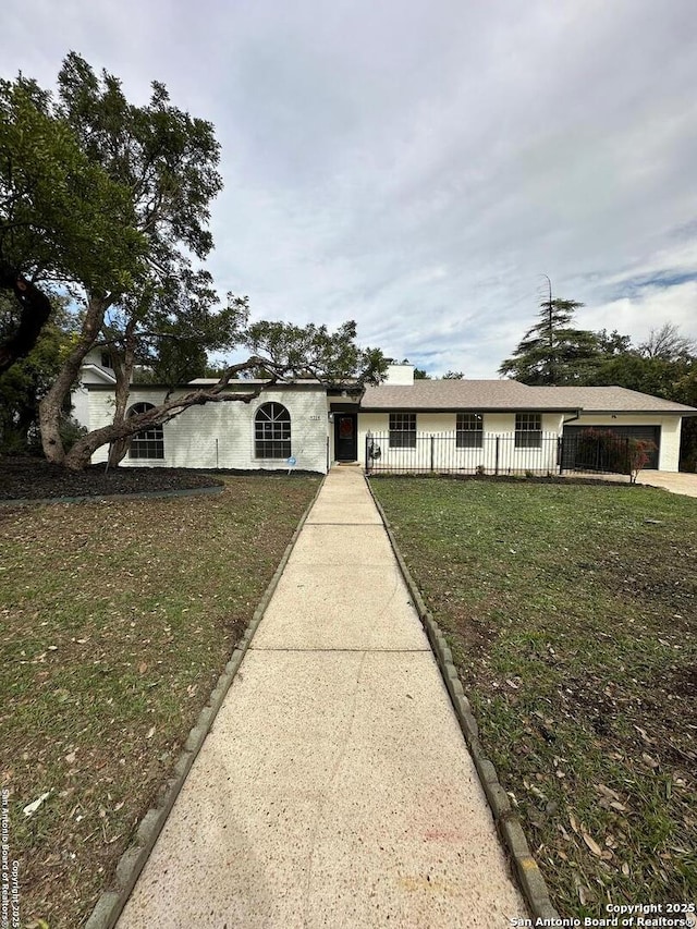 ranch-style house with a garage and a front lawn