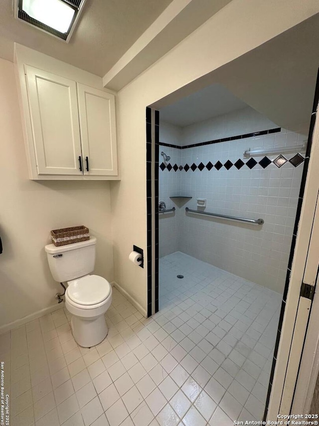 bathroom with tiled shower, tile patterned floors, and toilet