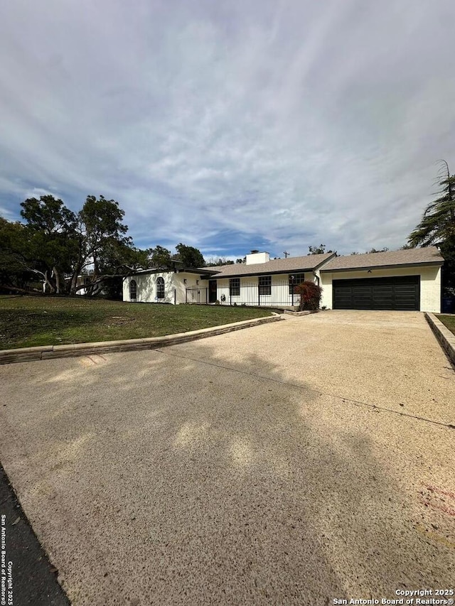 ranch-style home featuring a garage and a front yard