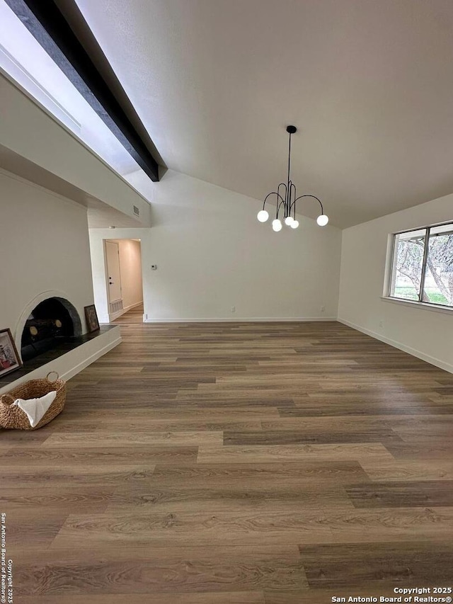 unfurnished dining area with lofted ceiling with beams, hardwood / wood-style flooring, and a notable chandelier