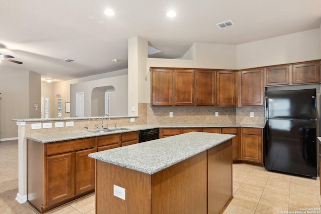 kitchen with a kitchen island, sink, decorative backsplash, and black appliances