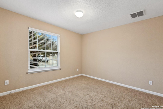 carpeted empty room featuring a textured ceiling