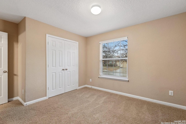 unfurnished bedroom with carpet, a textured ceiling, and a closet