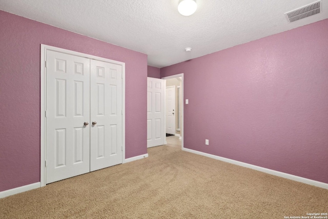 unfurnished bedroom with carpet flooring, a closet, and a textured ceiling