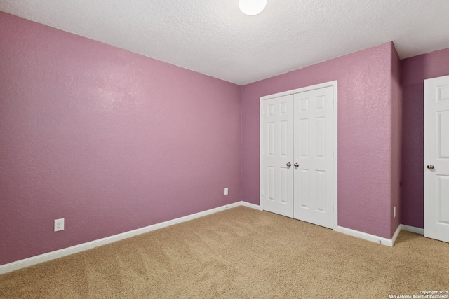 unfurnished bedroom with carpet, a textured ceiling, and a closet