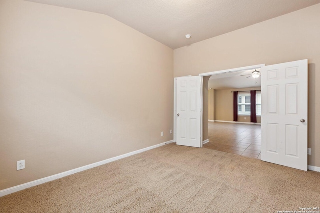 empty room with ceiling fan, lofted ceiling, and light carpet