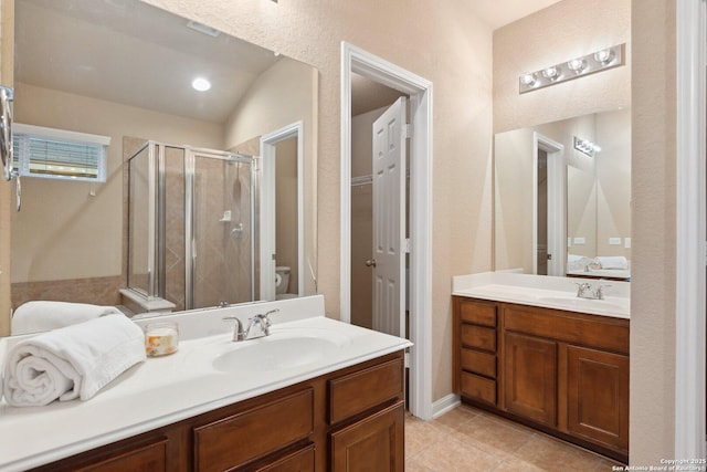 bathroom featuring tile patterned flooring, vanity, toilet, and walk in shower