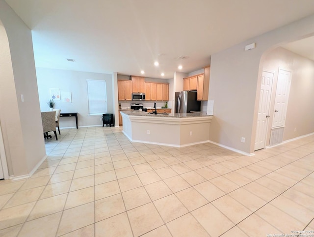 kitchen featuring light tile patterned flooring, appliances with stainless steel finishes, sink, and kitchen peninsula