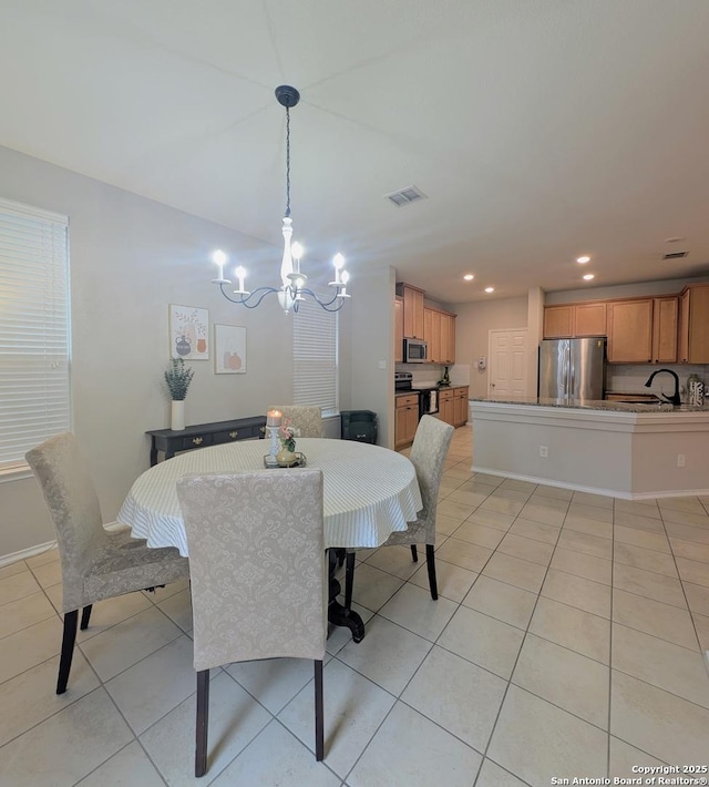 dining area with a notable chandelier, sink, and light tile patterned floors