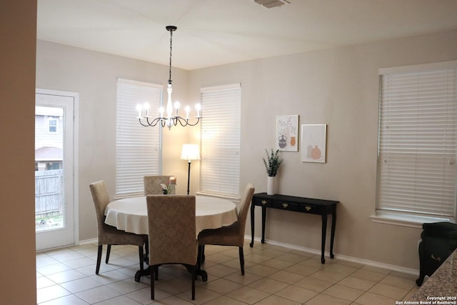 tiled dining space with a chandelier