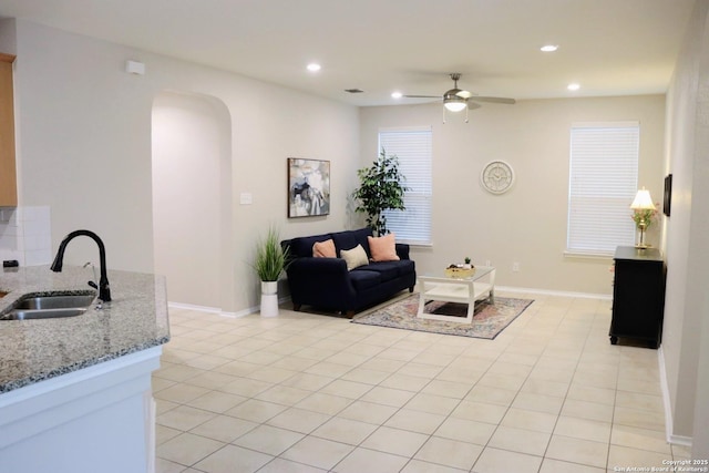 tiled living room with sink and ceiling fan