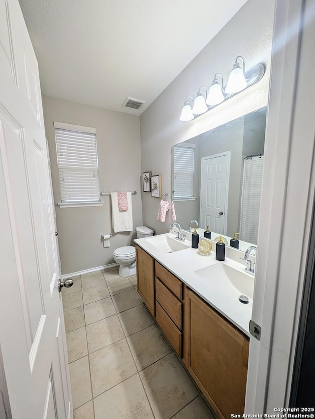 bathroom with vanity, toilet, and tile patterned flooring