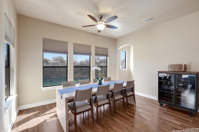 dining area with wine cooler, wood-type flooring, and ceiling fan