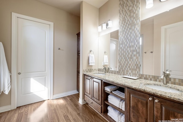 bathroom featuring wood-type flooring, vanity, and backsplash