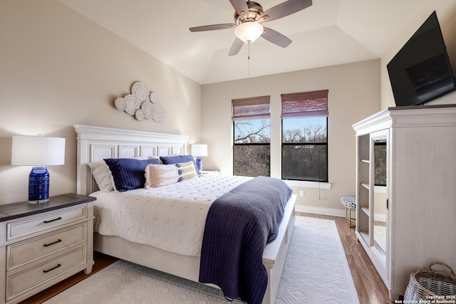 bedroom featuring ceiling fan, lofted ceiling, and light hardwood / wood-style floors