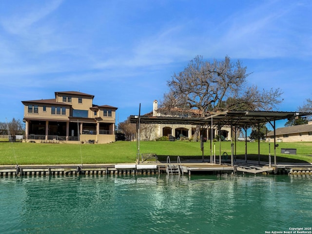 back of property featuring a water view and a lawn