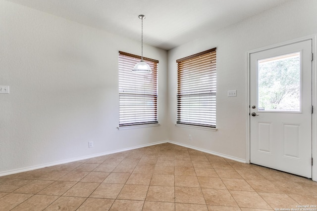 unfurnished dining area with light tile patterned floors and a healthy amount of sunlight