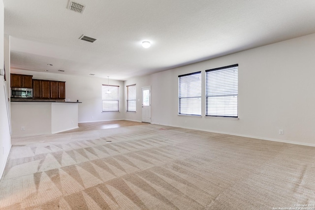 unfurnished living room featuring light colored carpet