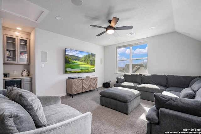 living room with lofted ceiling, ceiling fan, light carpet, beverage cooler, and indoor bar