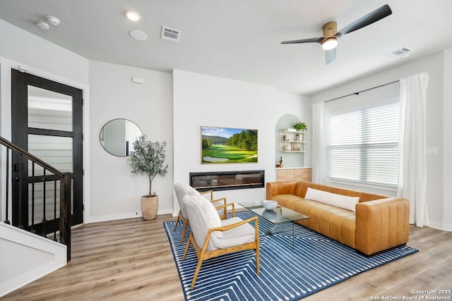 living room featuring ceiling fan and light hardwood / wood-style floors