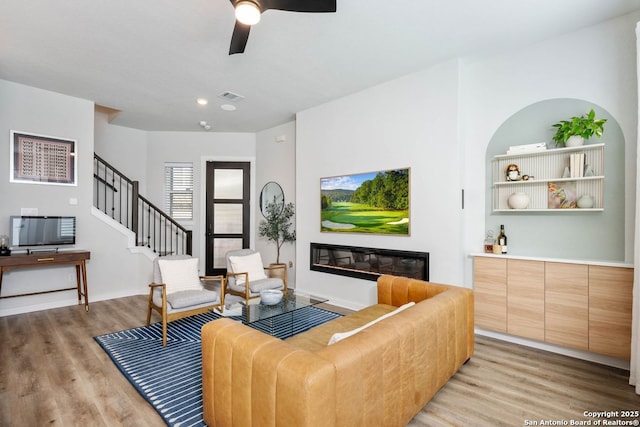 living room featuring ceiling fan and light hardwood / wood-style flooring