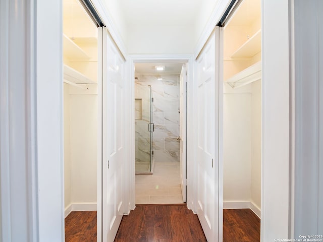 hallway with a barn door and dark hardwood / wood-style flooring