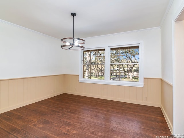 empty room with an inviting chandelier, ornamental molding, and dark hardwood / wood-style flooring