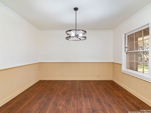 unfurnished room with ornamental molding, dark wood-type flooring, and a chandelier