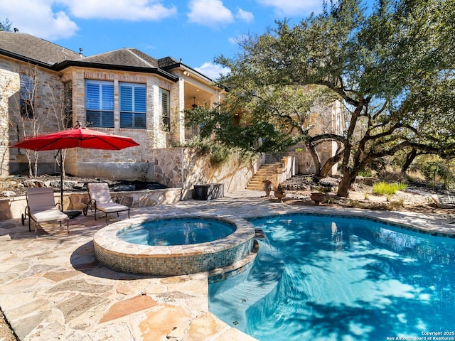 view of swimming pool with an in ground hot tub and a patio area