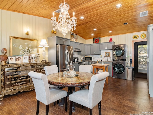 dining room featuring stacked washer / drying machine, wood ceiling, dark wood-type flooring, and a notable chandelier