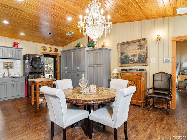 dining space with wood ceiling, stacked washer and dryer, dark hardwood / wood-style floors, and vaulted ceiling