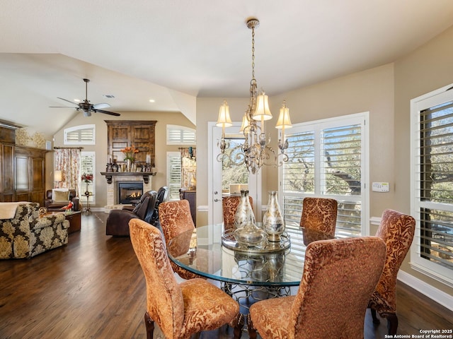 dining room with lofted ceiling, dark hardwood / wood-style flooring, and ceiling fan with notable chandelier