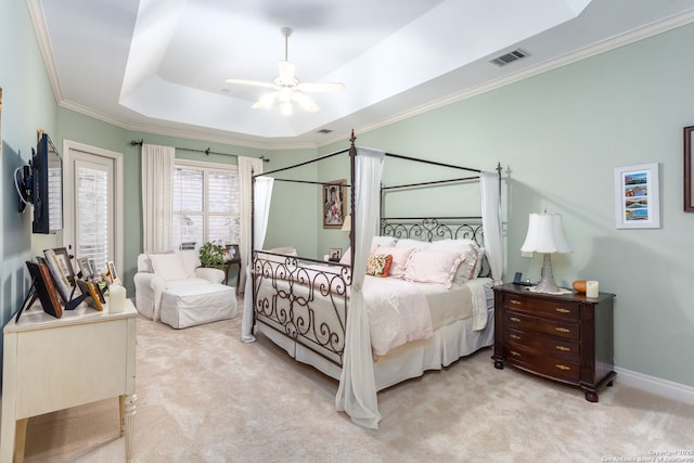 carpeted bedroom featuring crown molding, a raised ceiling, and ceiling fan