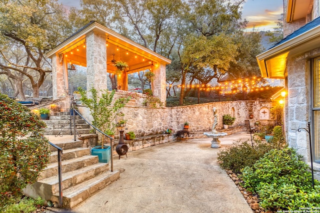 patio terrace at dusk featuring ceiling fan