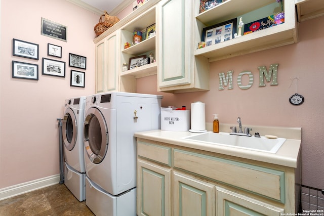 clothes washing area featuring cabinets, washer and clothes dryer, and sink