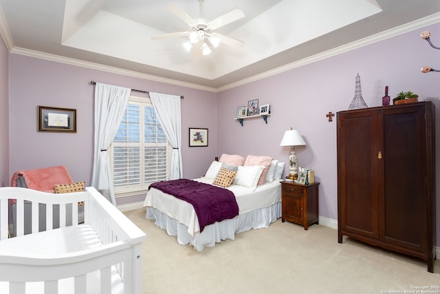 carpeted bedroom featuring crown molding, a raised ceiling, and ceiling fan