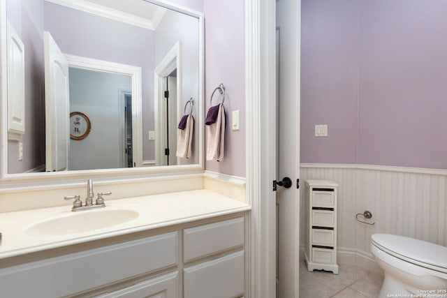 bathroom with tile patterned flooring, ornamental molding, vanity, and toilet